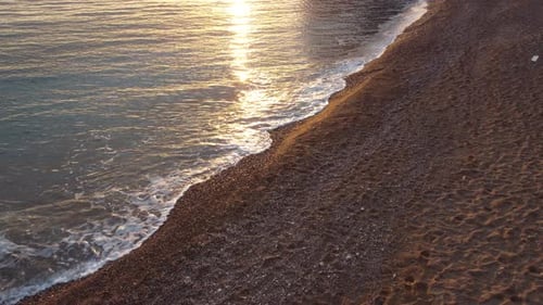 Panoramaaufnahme des wunderschönen Sonnenuntergangs über dem ruhigen azurblauen Meer und den vulkanischen Felsküsten