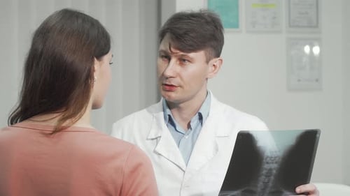 Doctor Discussing X-Ray with Woman in Clinic