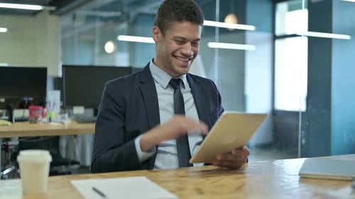 Young Man Video Calling on Tablet in Office