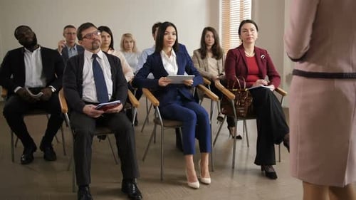 Diverse Audience Listens to Presentation in Meeting