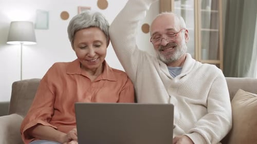 Senior Couple Video Calling on a Laptop at Home