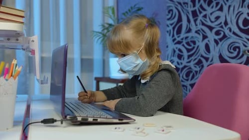 Child Learning on Laptop Wearing Face Mask