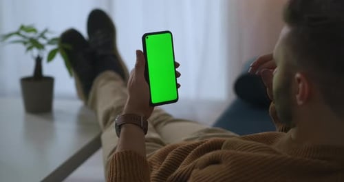 Man Is Calling By Video Chat in Smartphone From Home or Office at Break Time Green Screen on Gadget