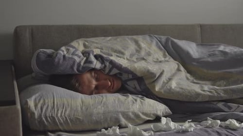 Person Sleeping Soundly Covered in Blanket in Bed