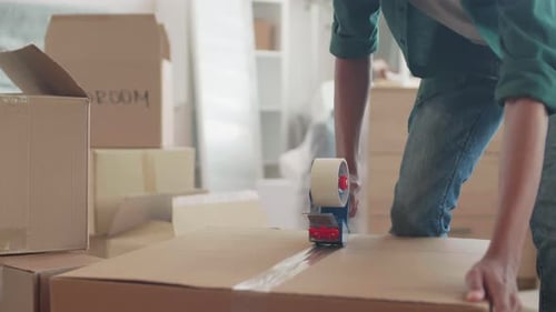 African Man Packing Boxes for Moving