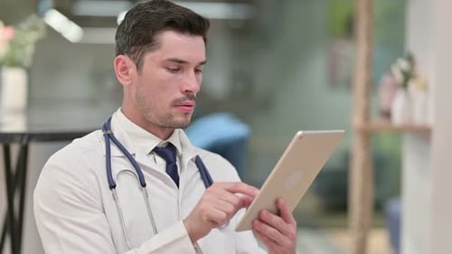 Male Doctor Using Tablet in Hospital Setting