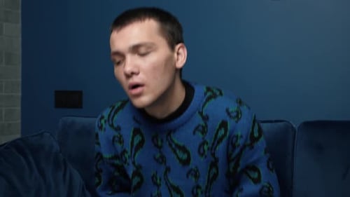 A Sad Depressed Caucasian Man Sits Holding His Head in His Hands. He Shakes His Head in Despair.