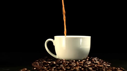 Pouring Coffee into Mug with Coffee Beans