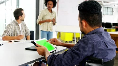 Man in Wheelchair Using Tablet in Office Meeting