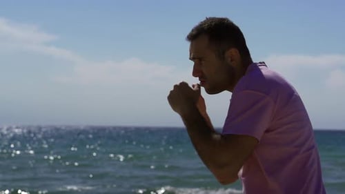 Strong Man Is Performing Hands Strikes in Open Air in Sunny Day Near Ocean, Training Alone