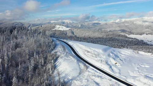 Aerial view on the road and forest in the winter time. Natural winter landscape from air