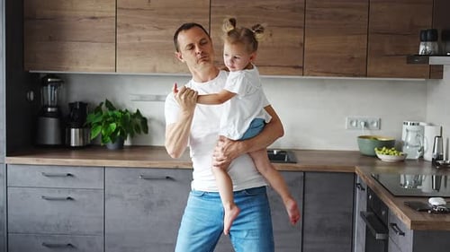 Loving Father Dancing with Child in Modern Kitchen