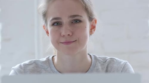 Blond Woman Looking into Laptop Camera