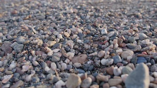 Small stones of different colours on the seaside, handheld close up