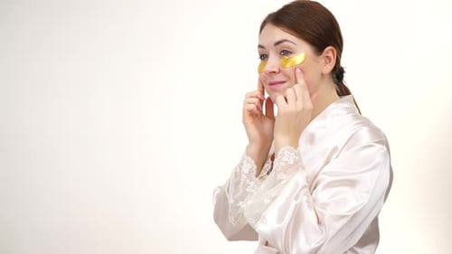 Woman Applies Gold Eye Patches for Beauty Treatment