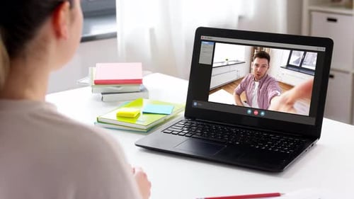 Frau mit Laptop führt Videoanruf zu Hause