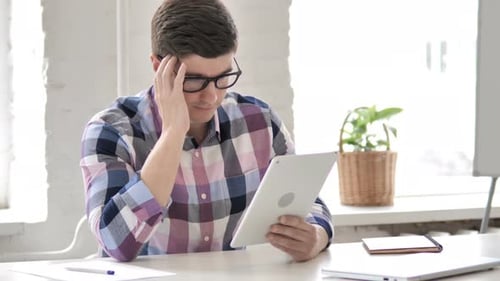 Young Man Reacting to Loss on Tablet