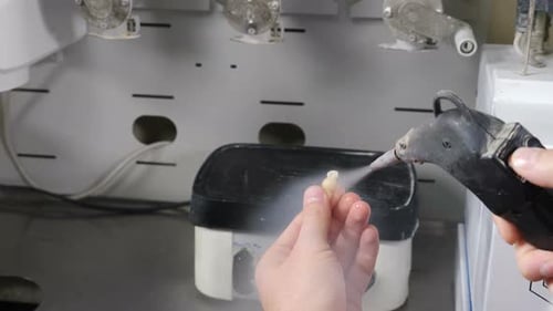 Dental Technician Cleans False Teeth in Lab