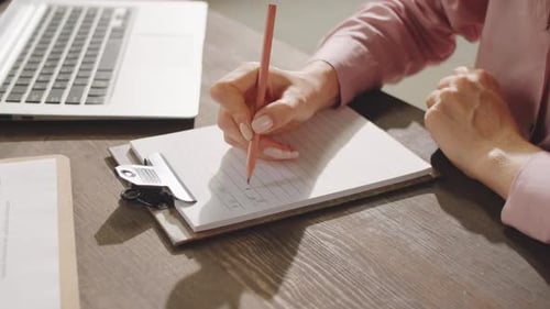 Hände der Geschäftsfrau, die mit Bleistift auf Papier schreiben