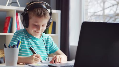 Child Learning at Desk with Laptop and Headphones