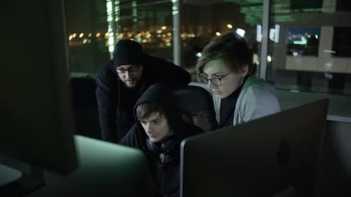 Tech Team Collaborates in Brightly Lit Office at Night