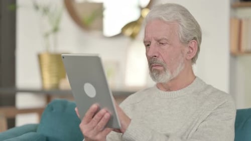 Adult Using Tablet While Sitting on Couch