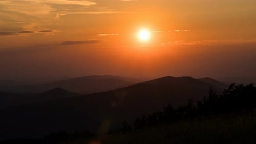 Sun Rising Over Mountains in Dramatic Landscape