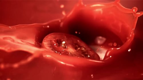 Super Slow Motion in Tomato Juice Drops a Piece of Tomato