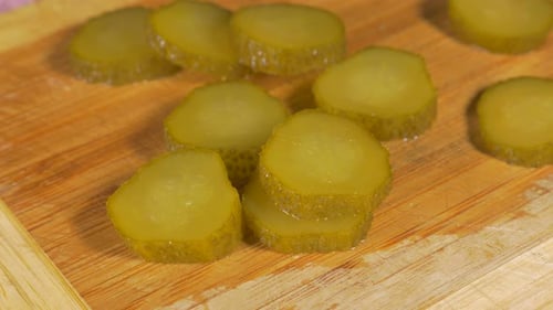 Pickled Cucumber Slices on Wooden Board