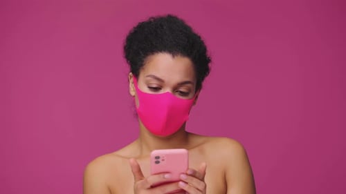 Woman With Mask Using Pink Cellphone