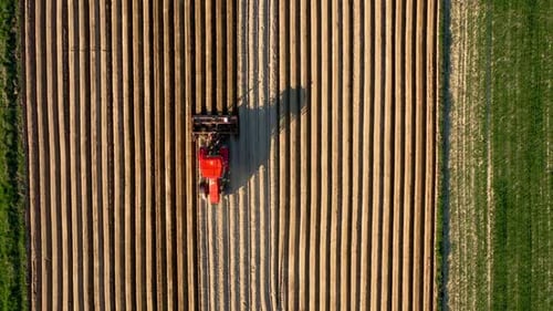 Aerial View of Tractor Performs Seeding on the Field