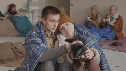 Portrait de jeune couple de réfugiés avec chat dans l'asile