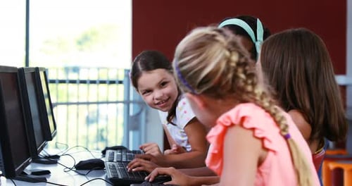 Smiling Students Working on Computers in Classroom