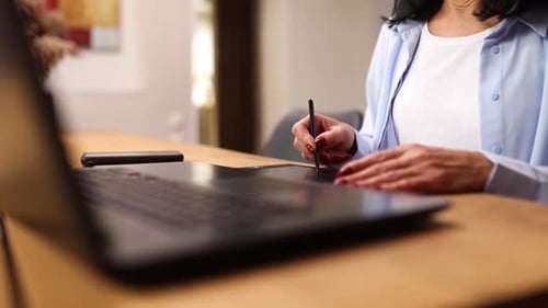 Woman Using Graphic Tablet at Wooden Table