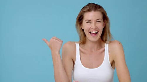 Smiling Woman Laughs and Points to the Side