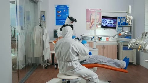Dentist and Assistant Examining Patient in a Clinic