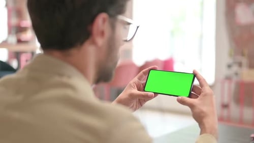 Young Adult Holding Phone with Green Screen Horizontally