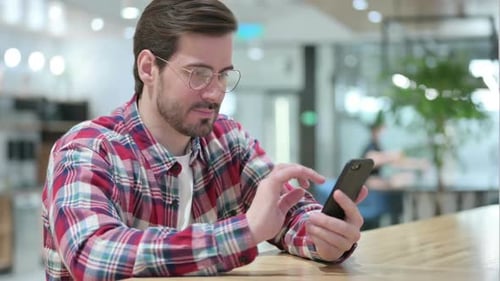 Young Adult Man Celebrates Using Smartphone