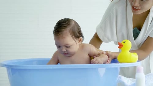 Baby in Tub Having Bath with Adult