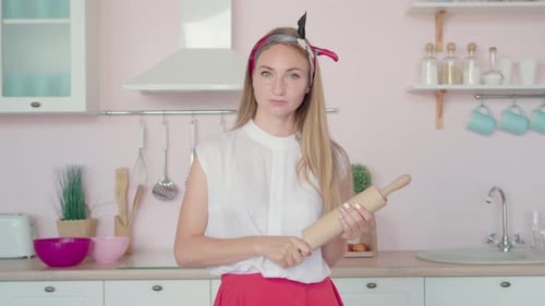 Woman Holds Rolling Pin in Kitchen
