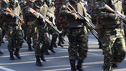 Camouflaged Soldiers Marching in Urban Military Parade