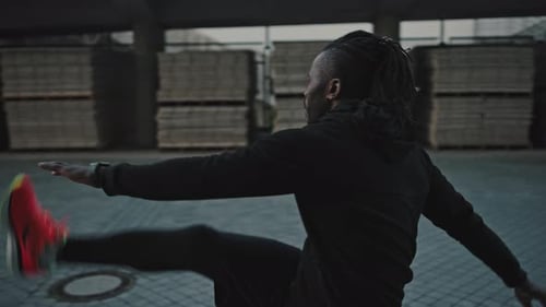 Active African American Athlete Warming Up Before Run Practice Stretching and Lifting His Legs