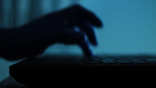 Silhouette der männlichen Handfläche beim Tippen auf der Laptoptastatur