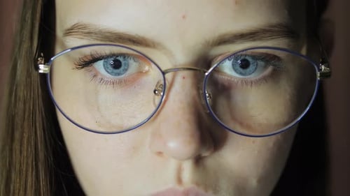 Closeup Eyes of a Teenage Girl with Glasses Looks at the Monitor Plays a Game Reads Studies