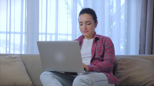 Woman Working on Laptop Indoors on Couch