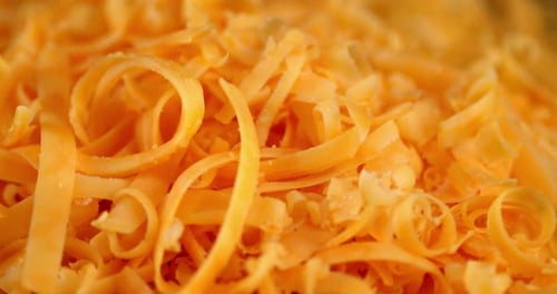 Small Pieces Grated Cheddar Cheese Slowly Rotate.