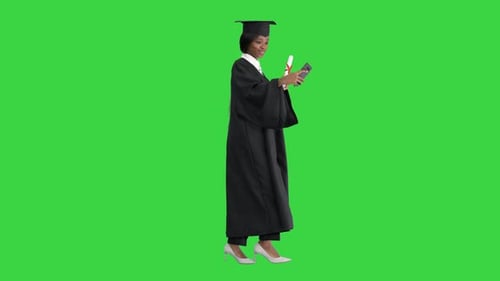 Smiling African American Female Graduate Making Selfie with Diploma on a Green Screen, Chroma Key.
