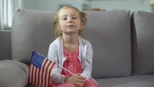 Little Girl Holding American Flag at Home
