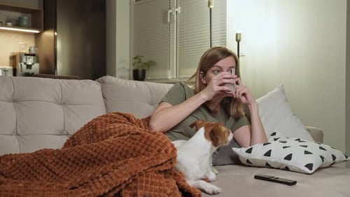 Woman Relaxing on Couch with Dog and Coffee