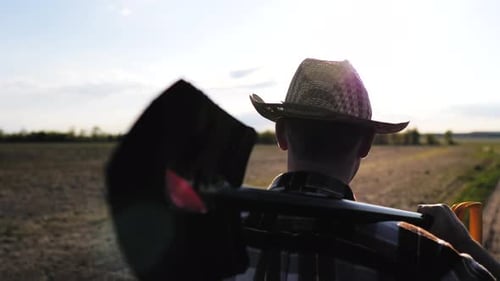 Adult Farmer Carries Shovel on Rural Farm